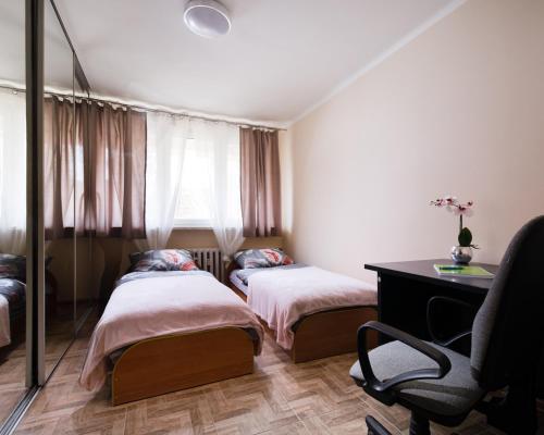 um quarto com 2 camas, uma secretária e uma cadeira em Apartament Deluxe Arcon Double em Siemianowice Śląskie