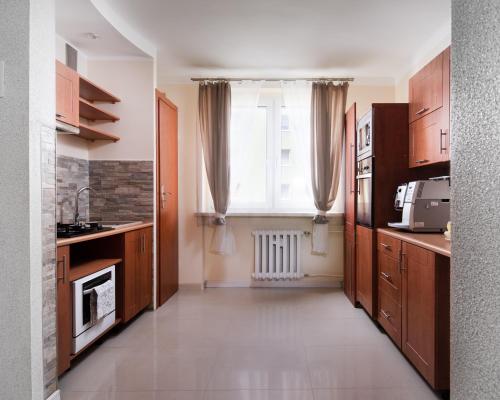 una cucina con armadi in legno e una grande finestra di Apartament Deluxe Arcon Double a Siemianowice Śląskie