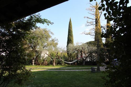 a park with trees and a hammock in the grass at Al vecchio fienile in Fagagna