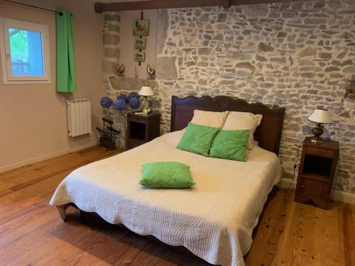 a bedroom with a bed with two green pillows on it at L Entre deux in Champcey