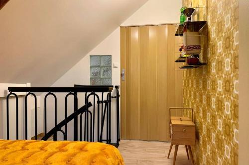 Un dormitorio con una cama amarilla y una escalera en Appartement Vintage avec vue sur le château, en Pierrefonds