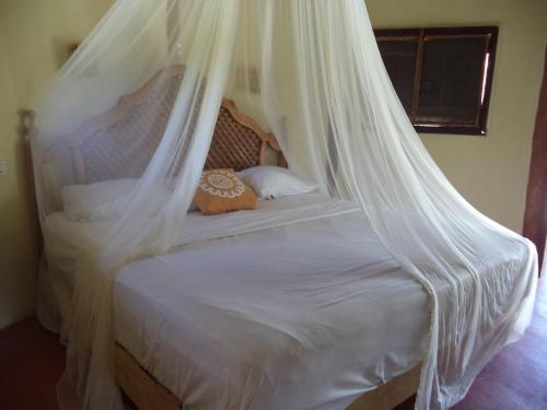 a white bed with a canopy in a room at Cabanas Jaalkab in Chelem