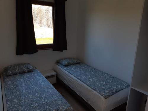 two beds in a room with a window at Choczewski Zakątek in Choczewo