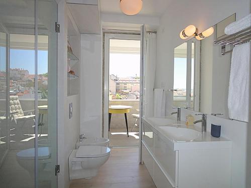 a white bathroom with a toilet and a sink at Panteao - Lissabon Altstadt in Lisbon