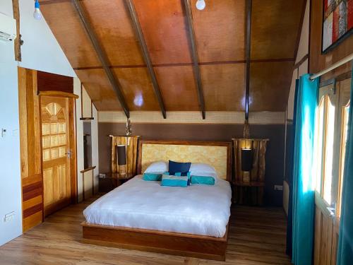 a bedroom with a bed with blue pillows on it at Mouggae Blues Villas in Beau Vallon