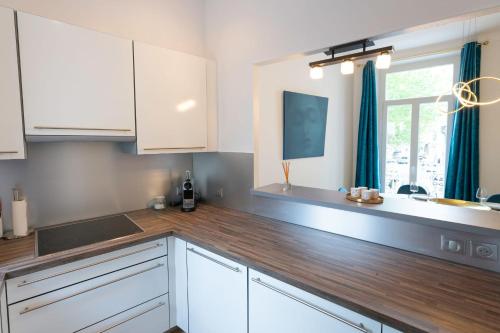 une cuisine avec des armoires blanches et un comptoir en bois dans l'établissement Modern 2-Br Apartment in the Heart of Cannes, à Cannes