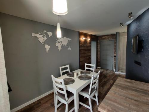 une salle à manger avec une table et des chaises blanches dans l'établissement Edžio apartamentai, à Palanga