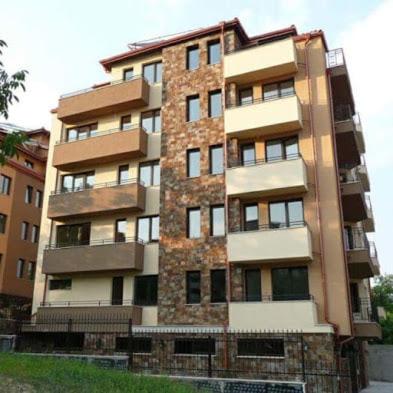 a tall brick building in front of a building at Апартаменти Елеганс in Sandanski