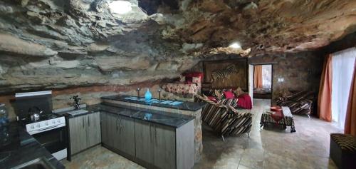 Il comprend une cuisine et un salon avec un mur en pierre. dans l'établissement Kings View Cave, à Clanville