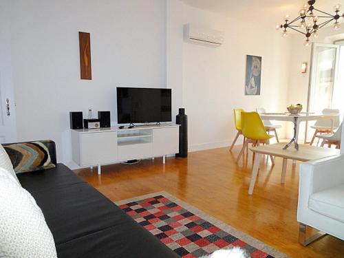 a living room with a television and a table with chairs at Panteao - Lissabon Altstadt in Lisbon