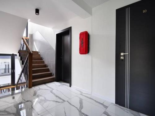 a hallway with a red suitcase on the wall and stairs at Fargo in Ustka
