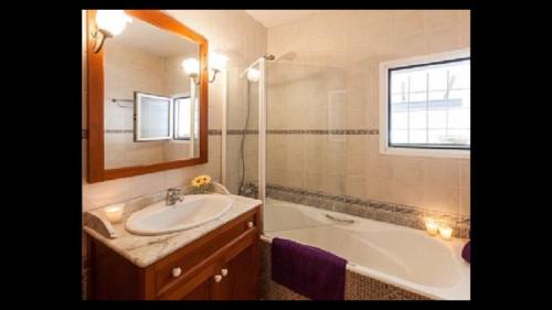 La salle de bains est pourvue d'un lavabo, d'une baignoire et d'un miroir. dans l'établissement Can Ballet, à Ibiza