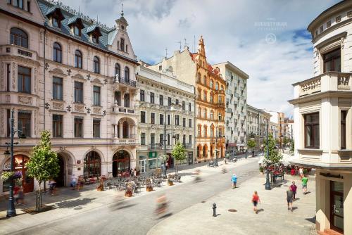 a group of people walking around a city street at Royal Aparthotel Piotrkowska 33 in Łódź