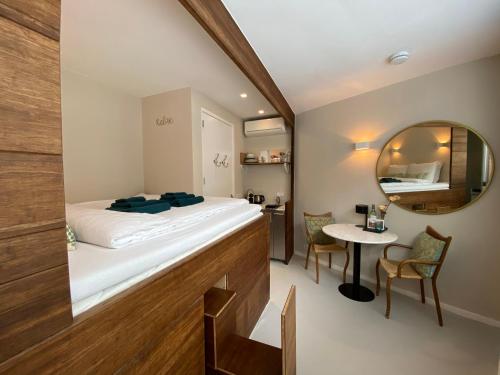 a room with a bed and a table and a mirror at Houseboat Sophia in Amsterdam