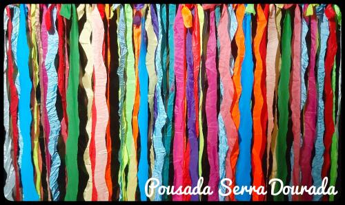 a bunch of colorful ribbons hanging in a wall at Pousada Serra Dourada in Goiás