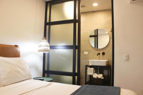 a bathroom with a bed and a mirror and a sink at 574 Hotel in Medellín