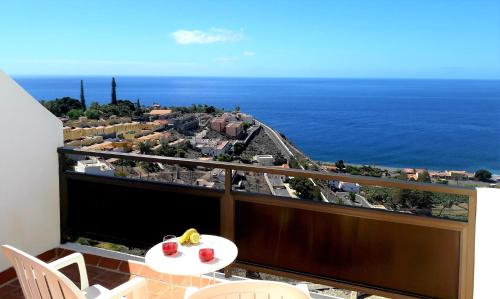 balcón con mesa y vistas al océano en casa mariposa, en Playa de Santiago