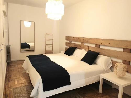 a bedroom with a large white bed and a mirror at CONTRASTES RIBEIRA SACRA in Monforte de Lemos