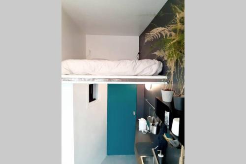 un lit sur un cadre de lit superposé dans une chambre dans l'établissement Small arty studio Menilmontant, à Paris