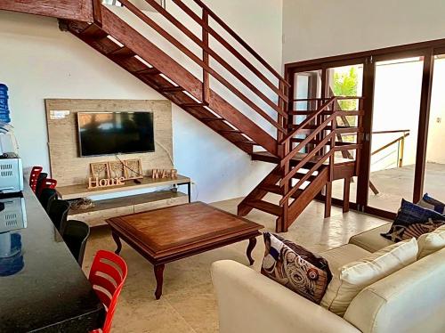 uma sala de estar com um sofá, uma mesa e uma televisão em Casa Taíba Beach Resort em Taíba