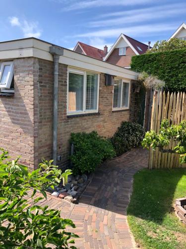 a brick house with a fence and a brick driveway at Fabel aan Zee in Zandvoort