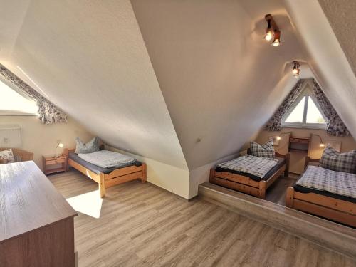 a attic room with three beds and a window at Strandbad in Horumersiel