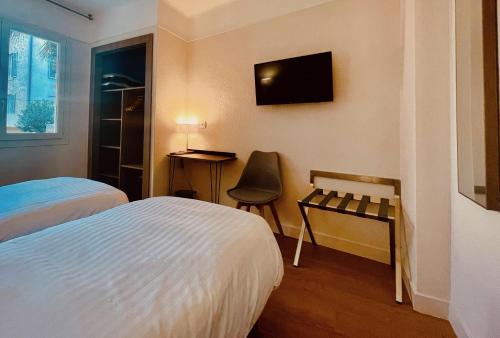 Hotel Courbet tesisinde bir odada yatak veya yataklar
