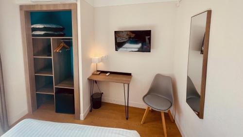 a bedroom with a desk and a mirror and a chair at Hotel Courbet in Juan-les-Pins