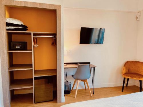 a bedroom with a bed and a desk and a tv at Hotel Courbet in Juan-les-Pins