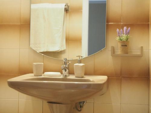 a bathroom with a sink and a mirror and towels at Casa Tierra Loutses in Loútsai