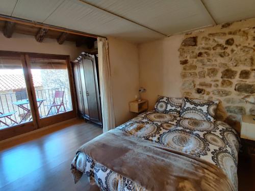 ein Schlafzimmer mit einem Bett und einer Steinmauer in der Unterkunft Loft Apartamento Rural La Fresneda - Casa Vidal in La Fresneda
