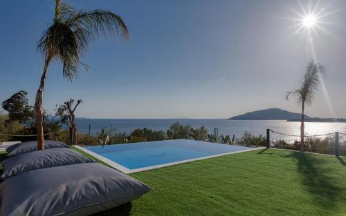 a swimming pool with a view of the water at Sounio Black Villa in Sounio