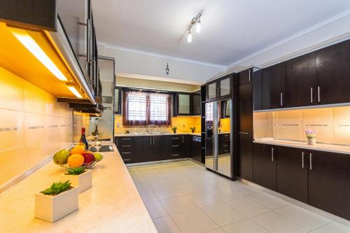 a kitchen with black cabinets and fruits on the counter at Maria's Luxurious Villa in Koskinou in Koskinou