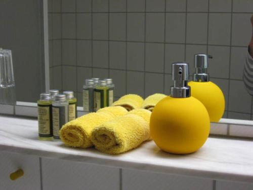 eine Badezimmertheke mit Handtüchern und 2 Flaschen Seife in der Unterkunft Hotel Pfälzer Hof, Zum Schokoladengießer in Rodalben
