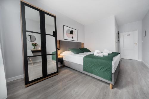 a bedroom with a bed and a large mirror at Villa Bluemica in Międzyzdroje