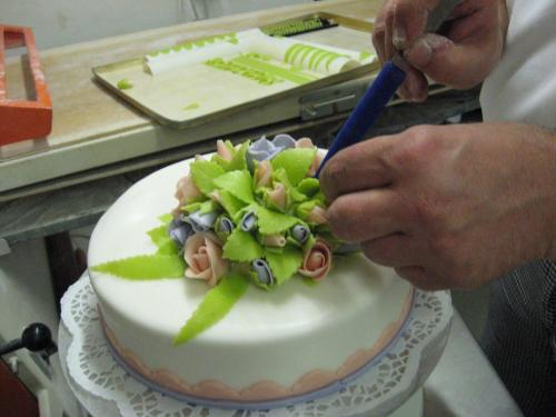 a person cutting into a cake with a knife at Hotel Pfälzer Hof, Zum Schokoladengießer in Rodalben