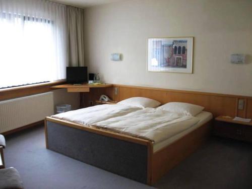 a bedroom with a large bed in a room at Hotel Pfälzer Hof, Zum Schokoladengießer in Rodalben