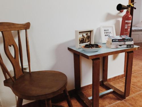 a wooden table with a chair and a desk with books at Casa do Douro in Alijó