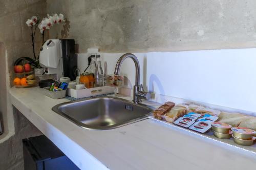 a kitchen counter with a sink with food on it at Loggia delle stelle in Matera