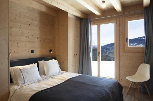 - une chambre avec un lit et une grande fenêtre dans l'établissement Bishorn COSY chalet 4 personnes, à Les Collons