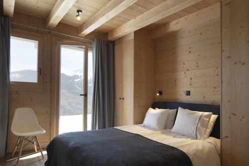 a bedroom with a bed and a large window at Bishorn COSY chalet 4 personnes in Les Collons
