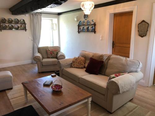 a living room with a couch and a coffee table at The Old Farm Gite in Amfreville