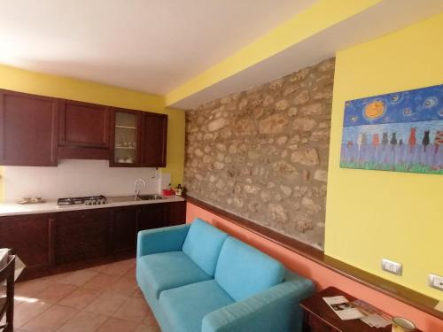 uma sala de estar com um sofá azul numa cozinha em Casale Le Due Querce em Ferentillo