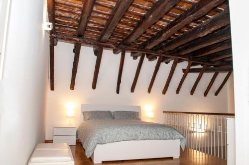 a bedroom with a white bed and wooden ceilings at Da Ale alla Cattedrale in Palermo