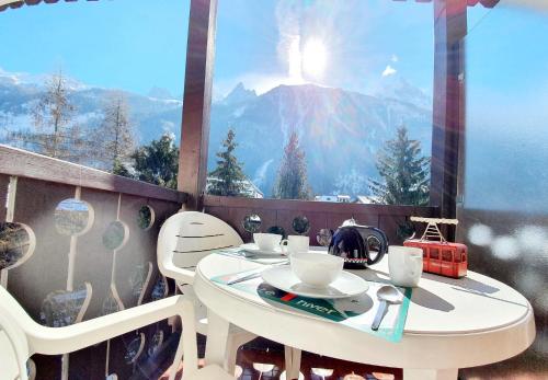 a table on a balcony with a view of a mountain at La Riviere Vue Mont Blanc in Chamonix