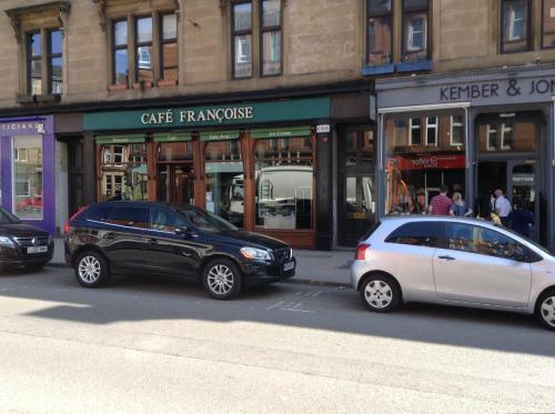 two cars parked in a parking lot in front of a store at Newhall in Glasgow
