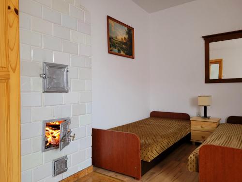 ゴニョンツにあるSłoneczna Dolina nad Biebrząのベッド2台と暖炉付きの部屋
