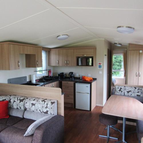 a kitchen and living room with a couch and a table at Barnkirk Holidays in Newton Stewart
