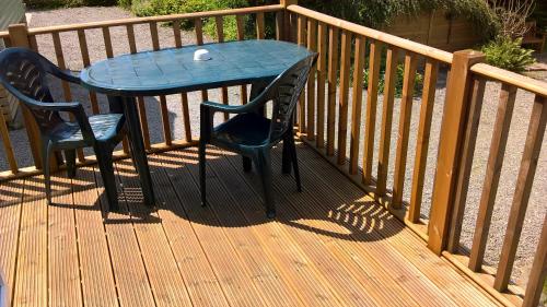 a blue table and two chairs on a wooden deck at Barnkirk Holidays in Newton Stewart