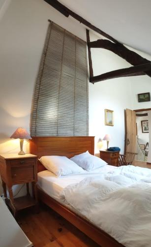 une chambre avec un lit et une table avec une lampe dans l'établissement Charming COTTAGE DU MARAIS DDAY OMAHA BEACH, à Canchy